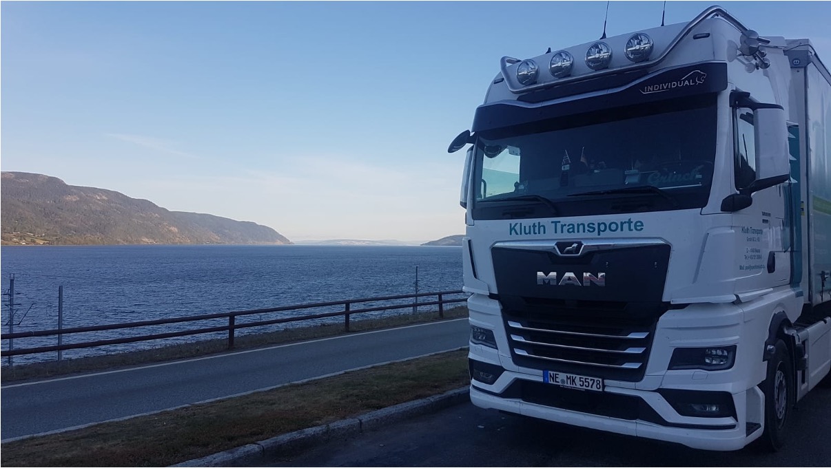 Weißer Kluth Lkw vor einer Fjordlandschaft
